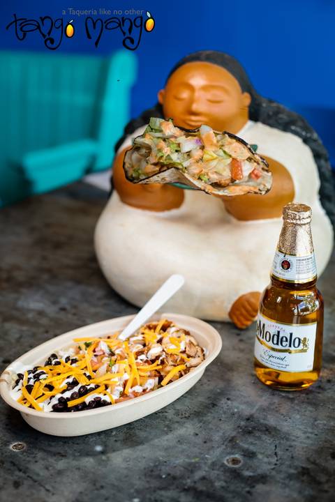 A sculpture in the dining room next to a bowl and a bottle of Modelo