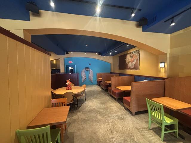 The back room, with wooden booths and the angel wings wall